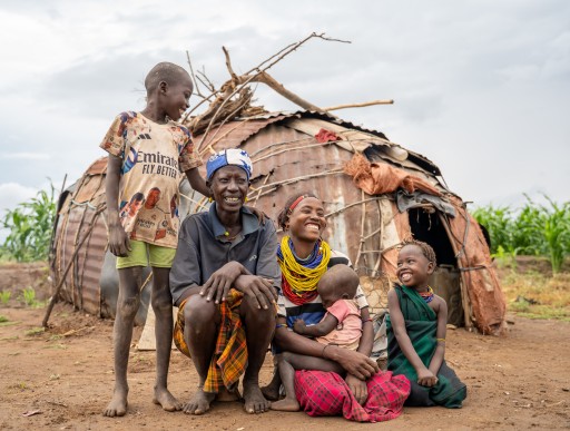 Donnay and family smiling at each other outside their home in Etheopia.